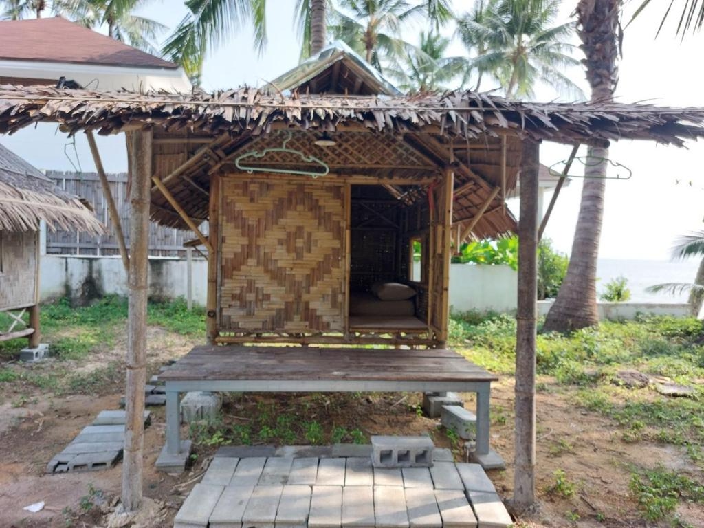 a small hut with a roof on a patio at Samui Camping Farm in Laem Sor