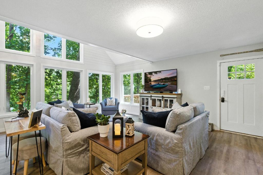 a living room with two couches and a table at The Holiday House w Dock in Townville