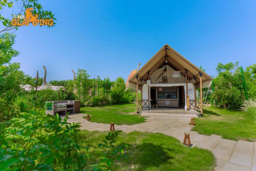 a small house with a thatched roof at T-Rex Glamping in Dubai