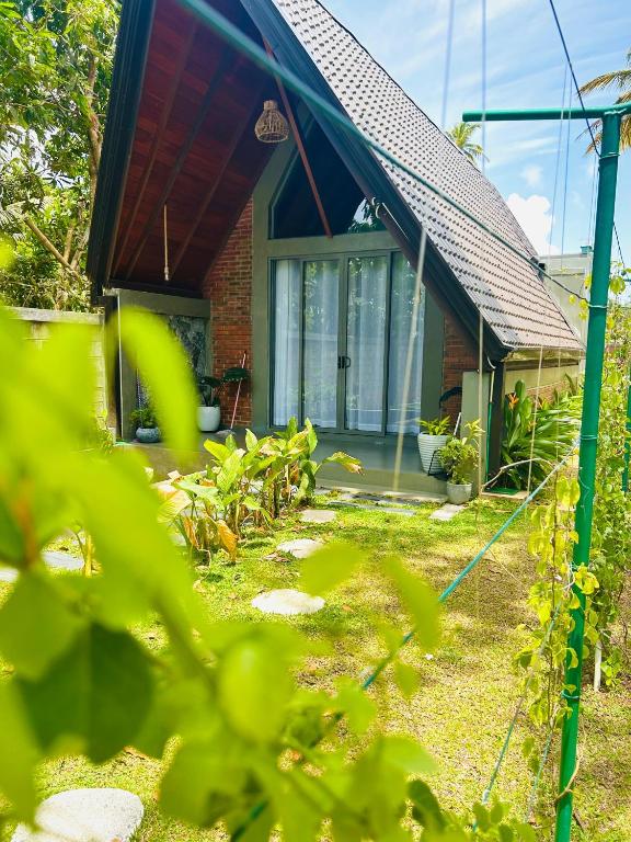 a house with a red roof and glass doors at Nirvana Lodges in Kumbalgama