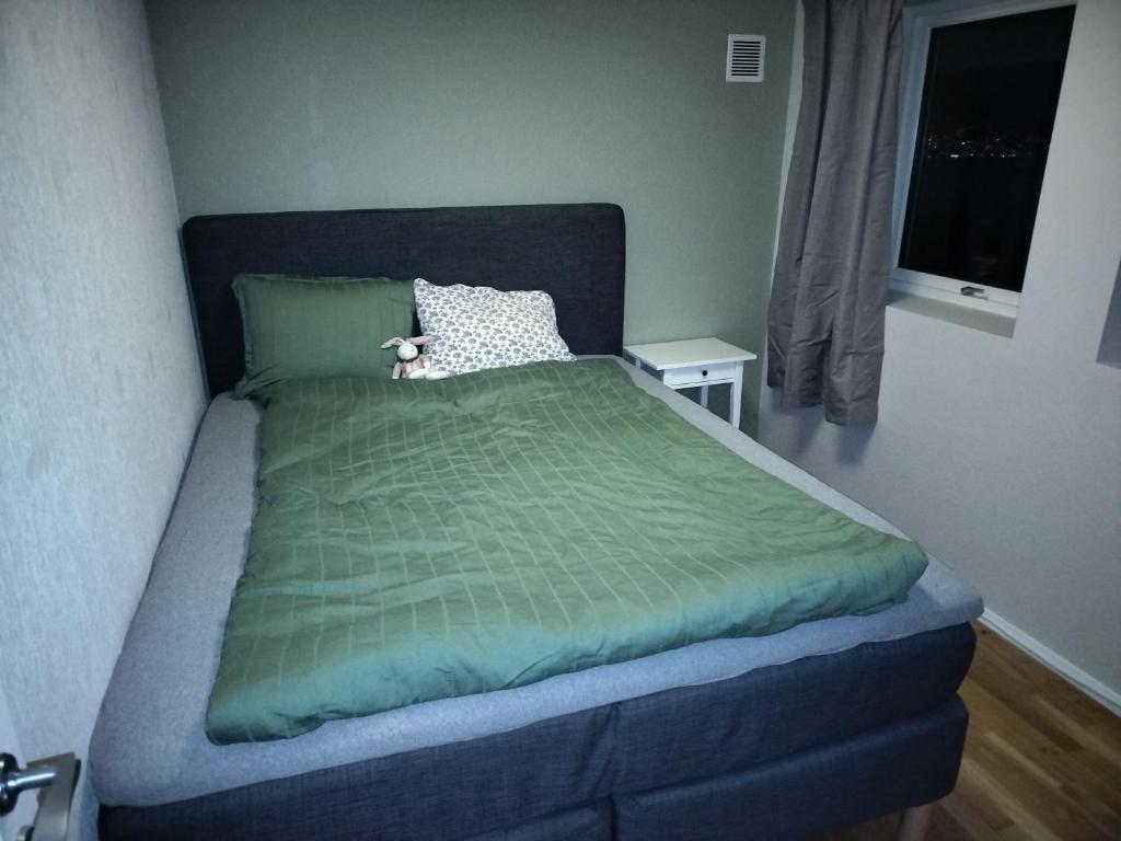 a bed with a green comforter in a bedroom at Prekestolen, Pulpit Rock in Strand