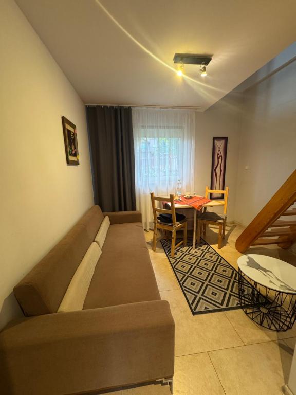 una sala de estar con un sofá y una mesa en Cozy Apartament, en Jelenia Góra