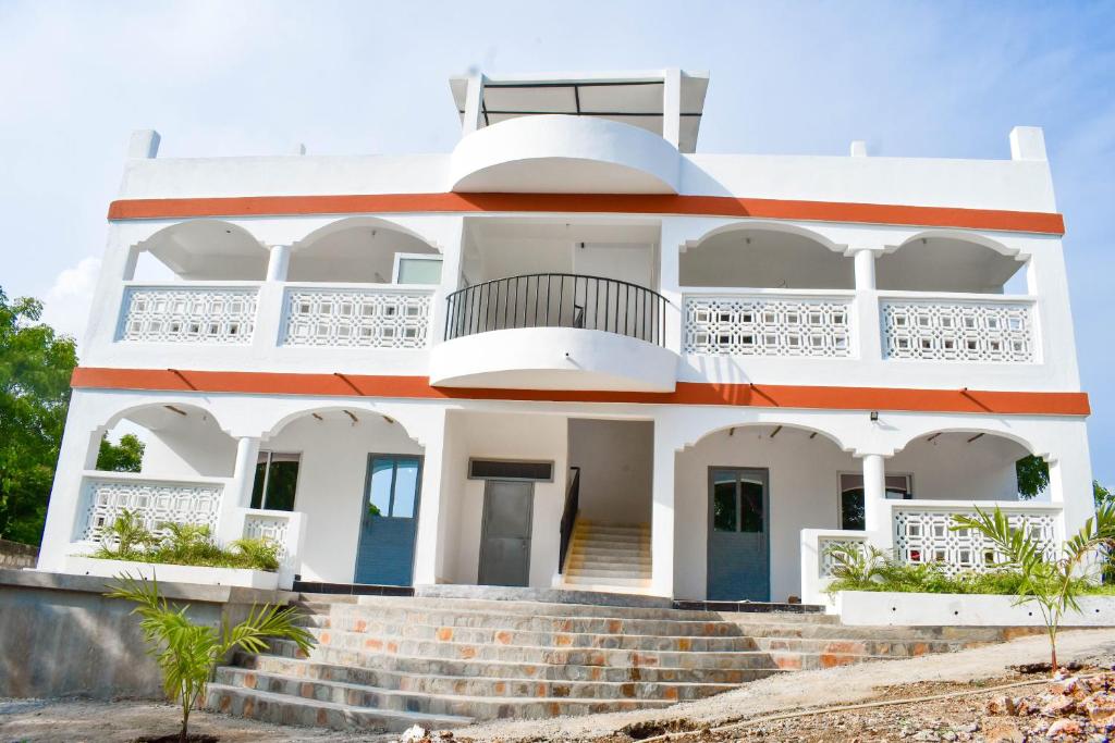 a white house with a staircase in front of it at Mangrove Sunset Villa in Watamu