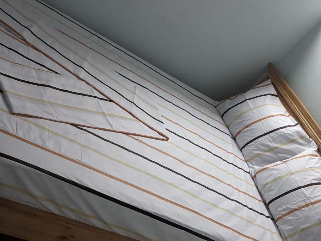 een bed in een kamer met witte en oranje strepen bij Blue Zone in Kigali