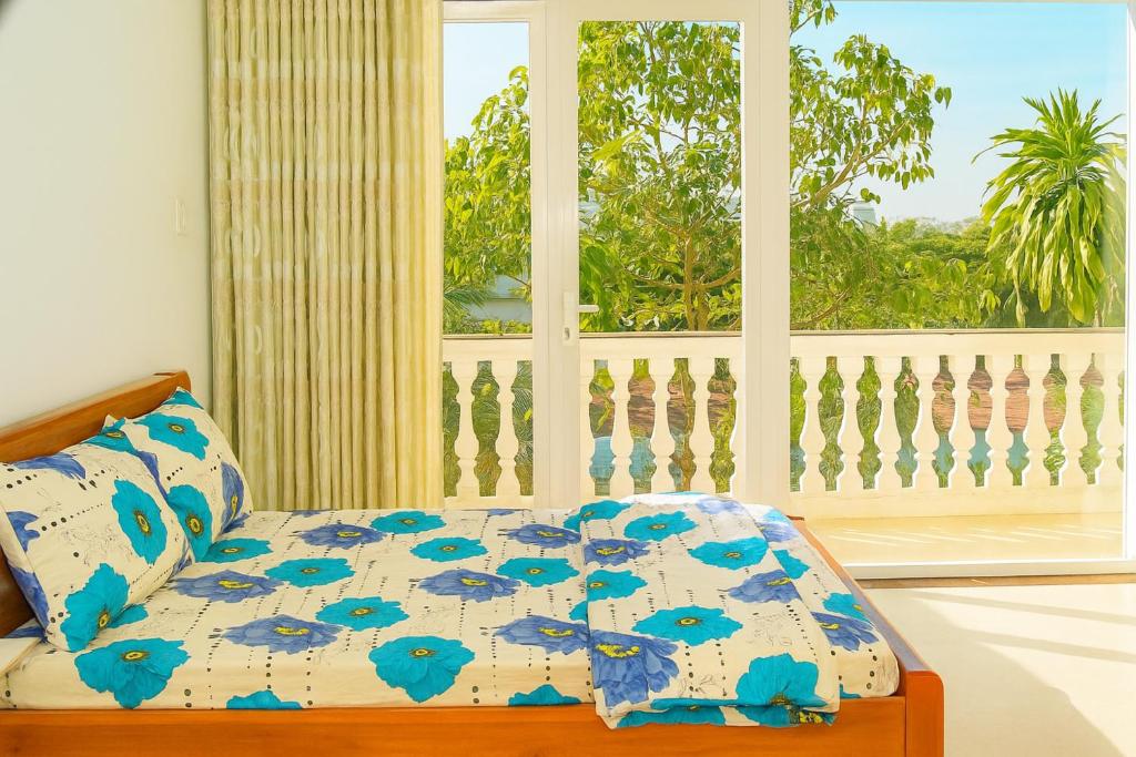 a bedroom with a bed with blue flowers on it at Khách sạn Hương Sen Sa Đéc in Sa Ðéc