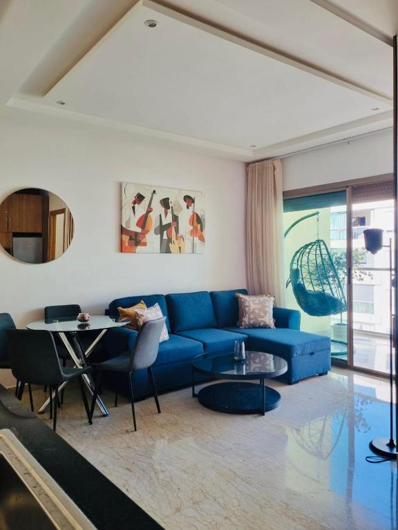 a living room with a blue couch and a table at BenHost Appartement Casablanca Maarif in Casablanca