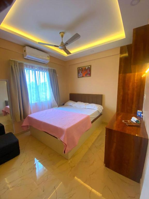 a bedroom with a bed and a ceiling fan at Lakeview Nest in kolkata