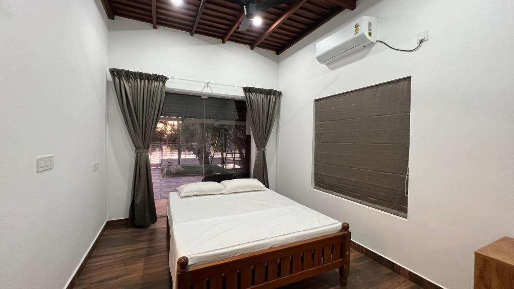 ein Schlafzimmer mit einem Bett und einem Fenster in der Unterkunft Vembanad Ripples in Alappuzha