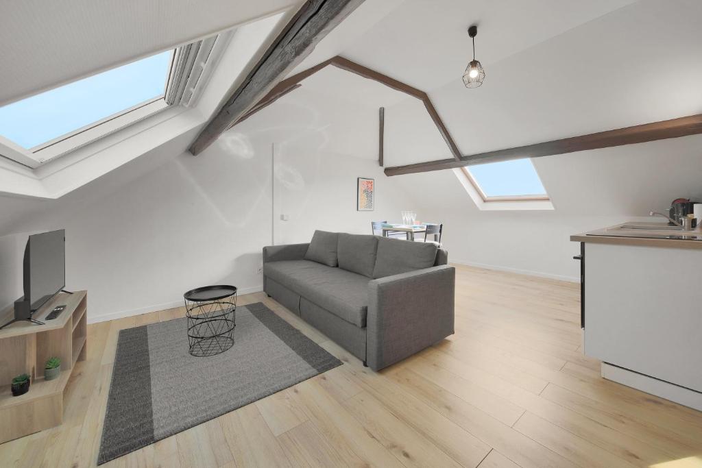 a living room with a couch and a tv at Dentelle in Caudry