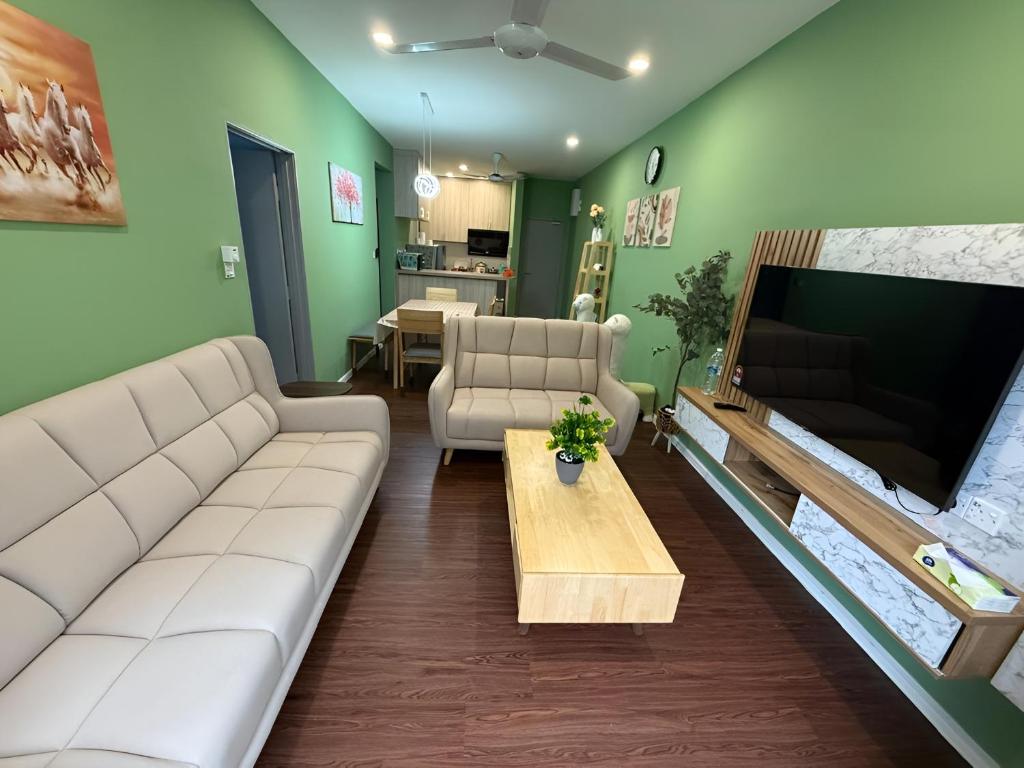 a living room with a couch and a tv at Cameron Palas Homestay in Brinchang