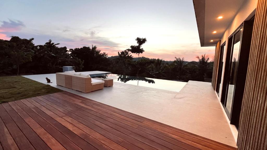 a deck with a couch sitting on top of a house at La Résidence - Siargao in General Luna