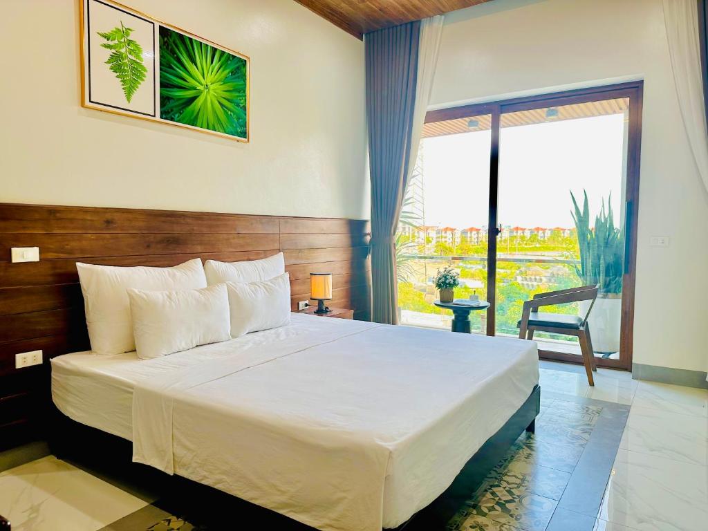 a bedroom with a large bed and a large window at Daisy's Villa TamCoc in Vũ Lâm
