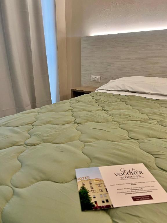a bed with a sign on top of it at Il Grifo Hotel e Bisteccheria Toscana in Montepulciano
