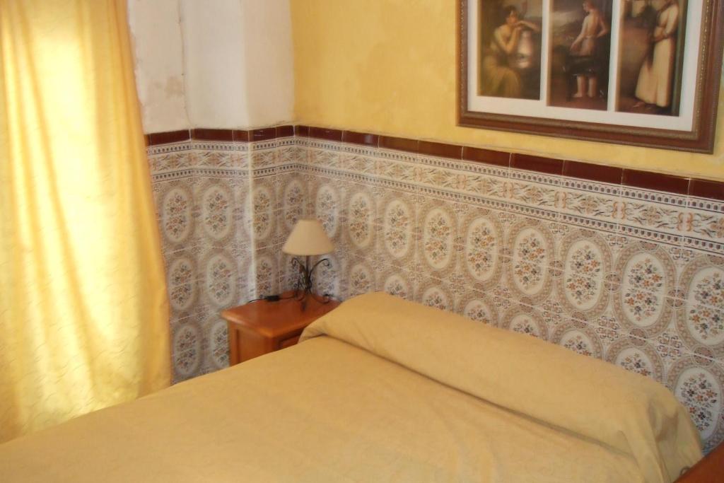 A bed or beds in a room at Hostal Alcázar