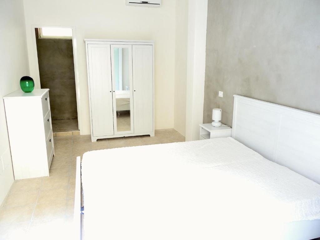 ナポリにあるLa Casaforte art residencyのベッドルーム(白いベッド1台、鏡付)