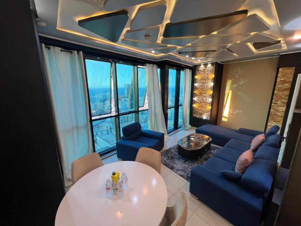 a living room with a white table and blue chairs at Santa View oran in Oran