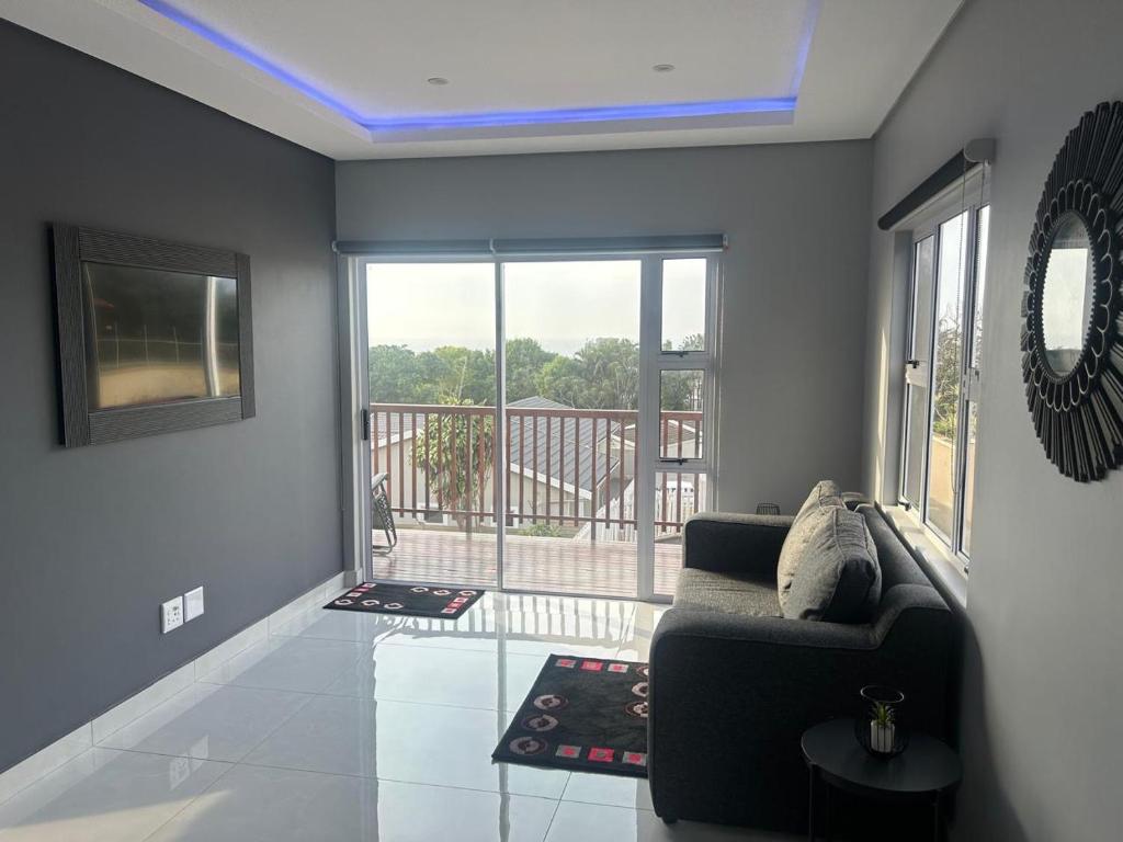 ein Wohnzimmer mit Couch und Balkon in der Unterkunft Kys Place in Durban