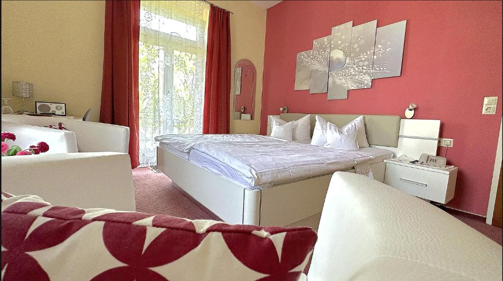 1 dormitorio con cama blanca y pared roja en HOTEL YOGA JASMIN ehemals Hotel Eberhardt-Burghardt, en Badenweiler