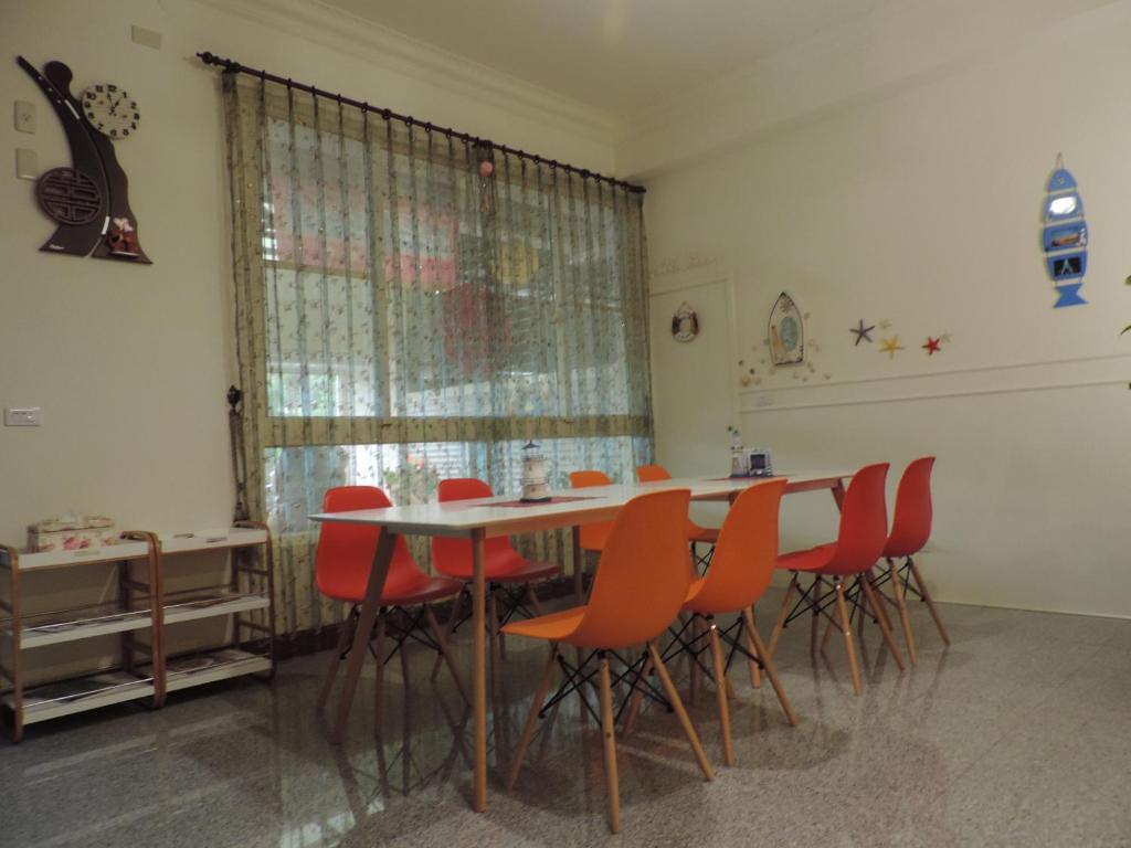 a dining room with a table and red chairs at Happy Life B&amp;B in Donggang