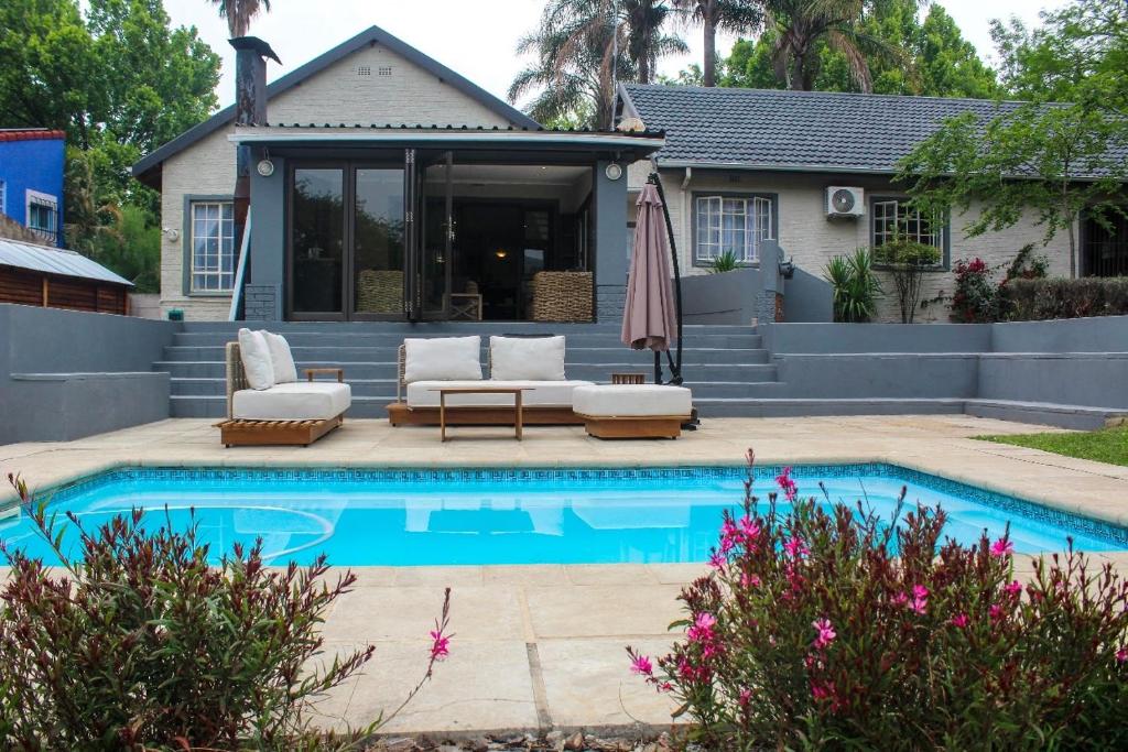 a swimming pool with a patio and a house at Newcastle Country Retreat in Newcastle