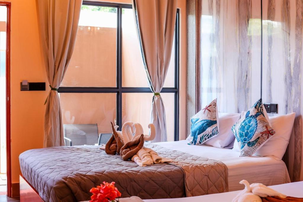 Un dormitorio con dos camas y una ventana. en Ari Stay Thoddoo, en Thoddoo
