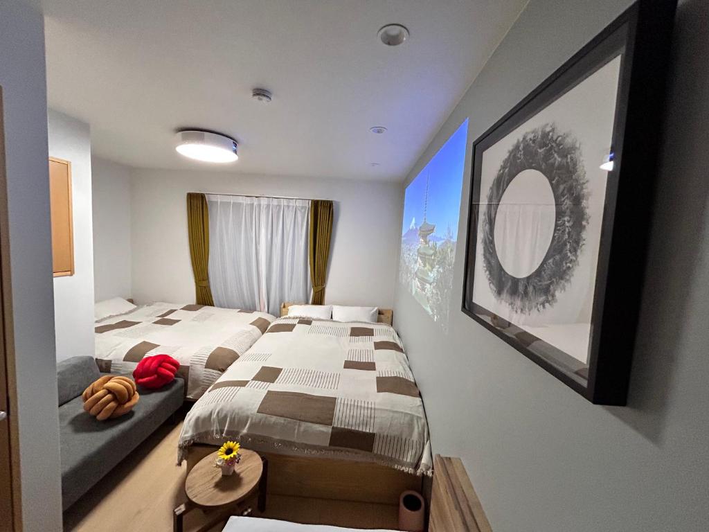a bedroom with two beds and a mirror on the wall at 77kawaramachi 新築 in Takamatsu