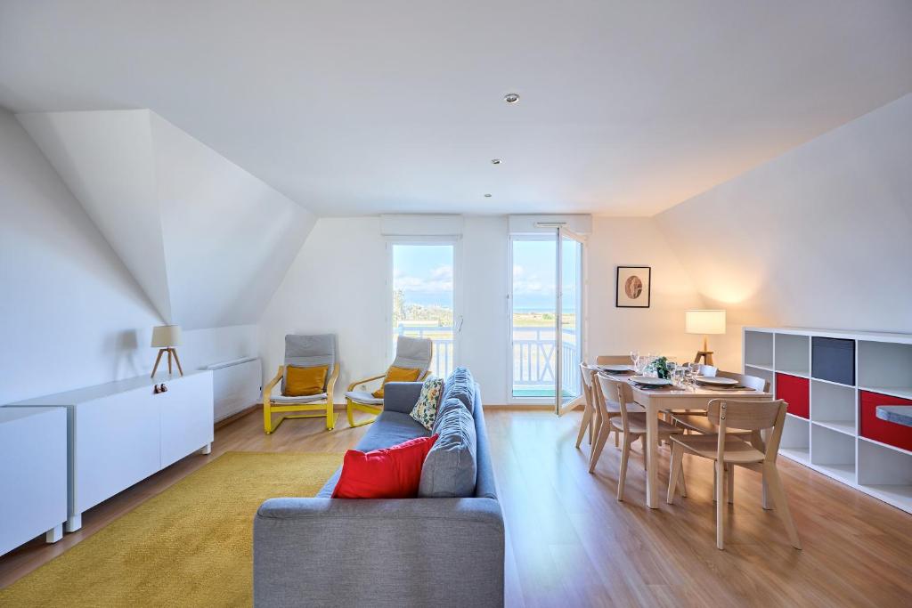 a living room with a couch and a table at Le Quai Bleu - 200 m de la plage in Courseulles-sur-Mer