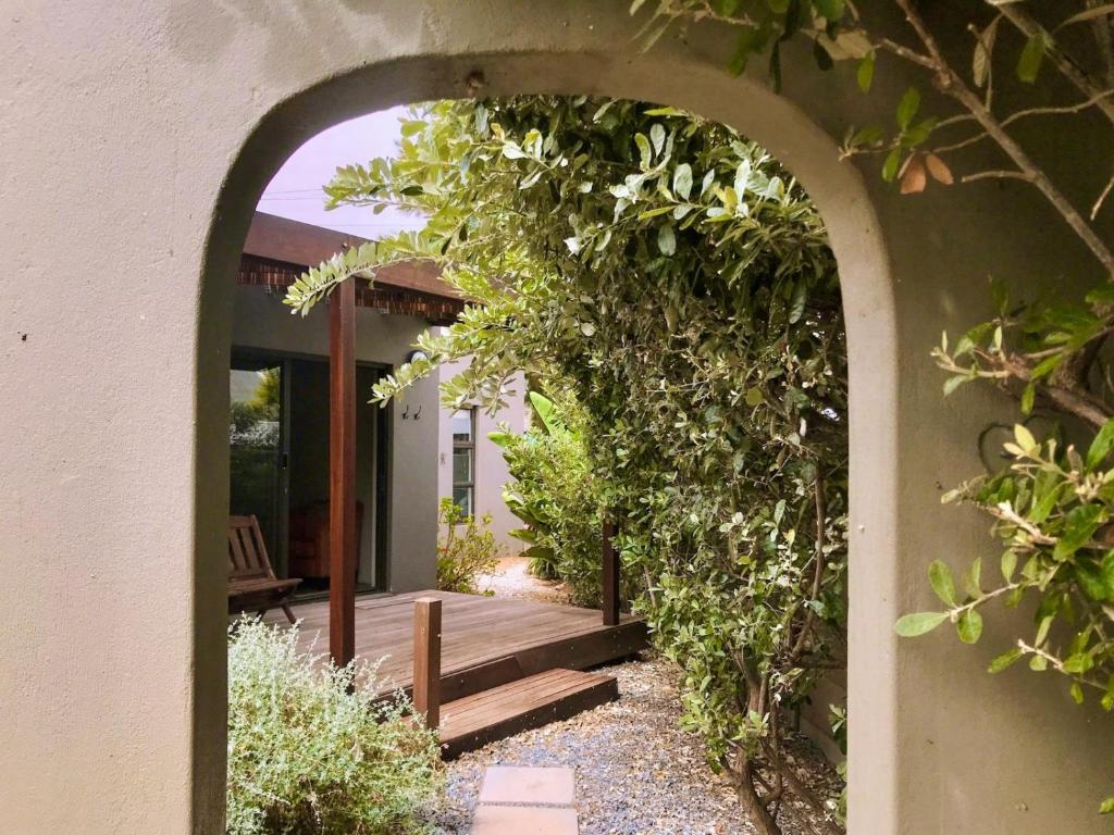 an archway leading to a porch with a wooden bench at Point Garden Cottage in Elands Bay