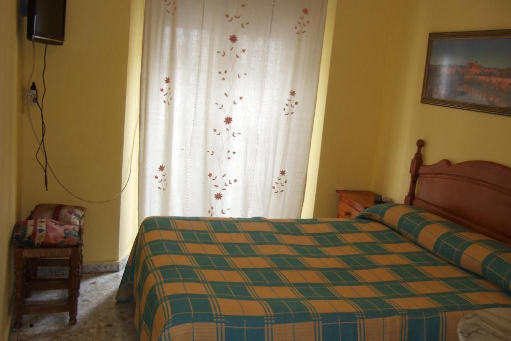A bed or beds in a room at Hostal Alcázar