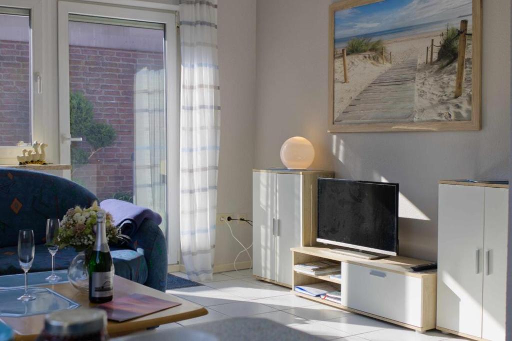 a living room with a blue couch and a television at Inselblume 39 - Komfortable Ferienwohnung mit Waschmaschine in Burg in Burg auf Fehmarn