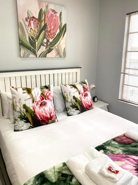 a bedroom with a bed with pink flowers on it at The Protea & Vine - Paarl - Self Catering Apartment in Paarl