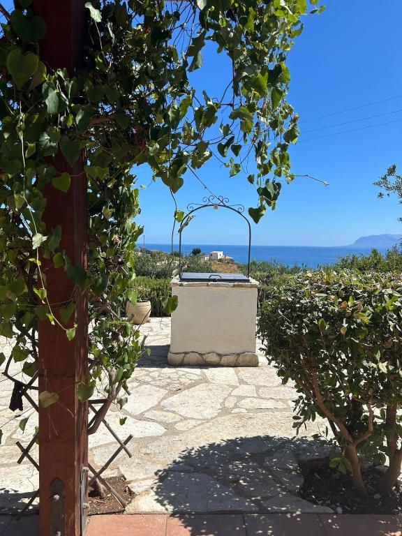a stone patio with a view of the ocean at A Casuzza di Poggio Scopello in Scopello