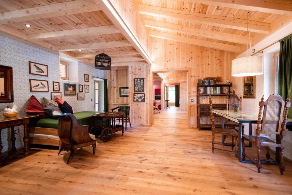 a large room with wooden floors and a room with a bed at Wohnung ASSUNTA in Soprabolzano