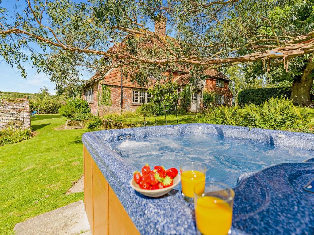 a bowl of tomatoes and two glasses of orange juice at 4 Bed in Icklesham BT067 in Icklesham