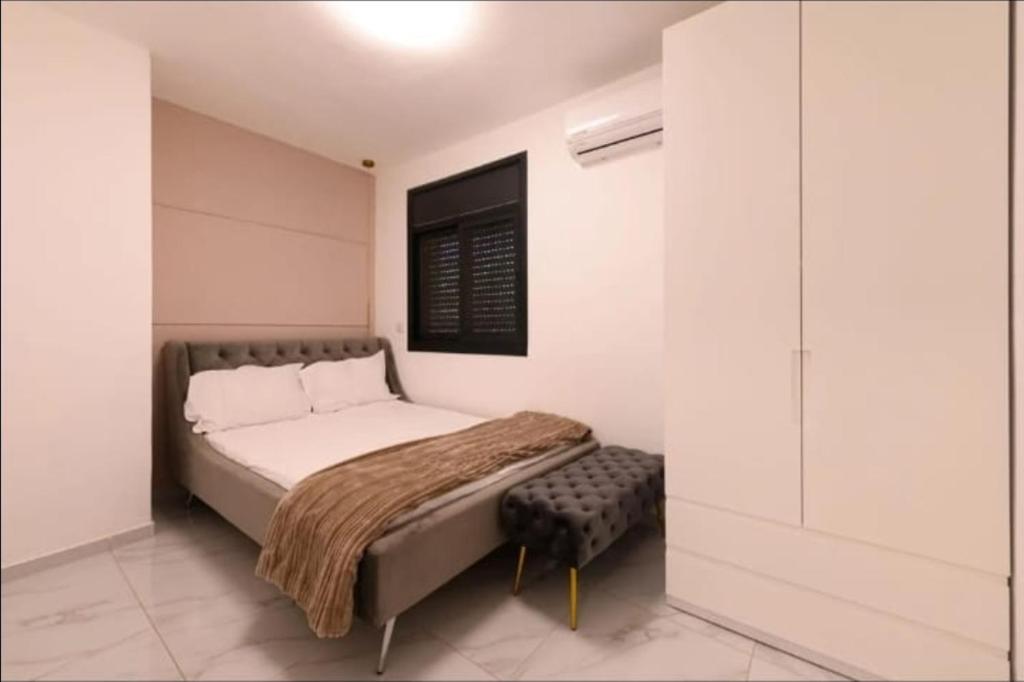 エルサレムにあるPERGOLA penthouse 3 bdr in centerの小さなベッドルーム(ベッド1台、スツール付)