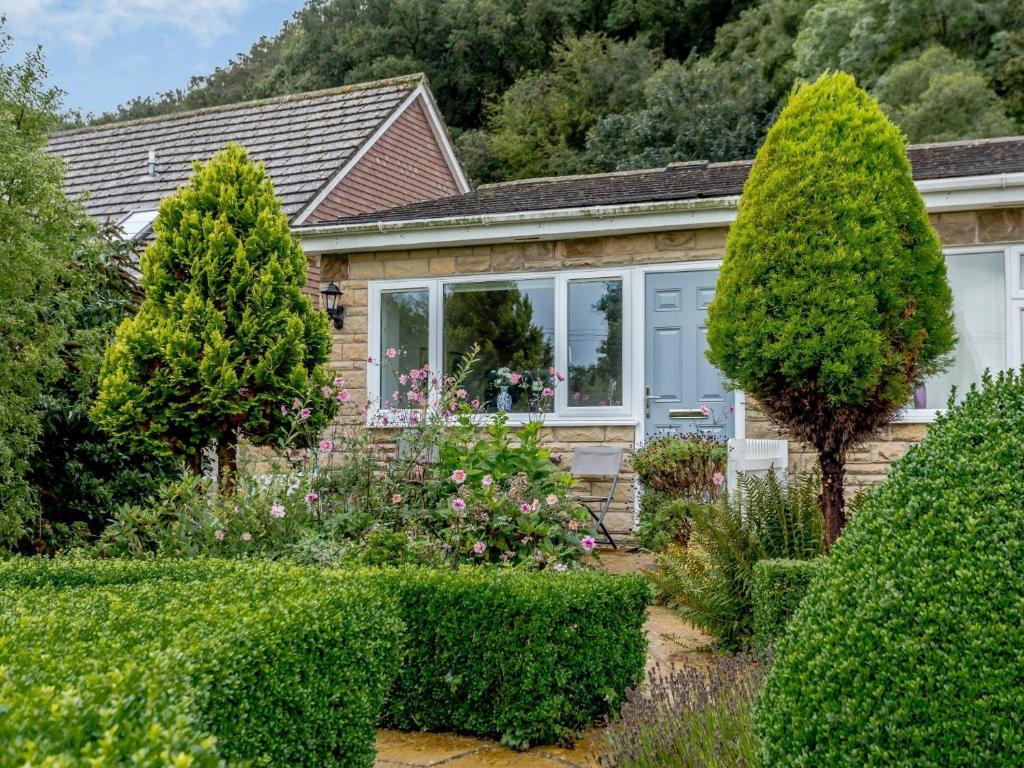 una casa con árboles y arbustos delante de ella en 1 Bed in Charmouth 57185, en Charmouth
