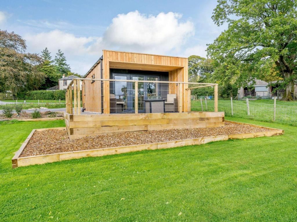 una pequeña casa de madera en un patio con césped en 1 Bed in Keswick 82476, en Bassenthwaite