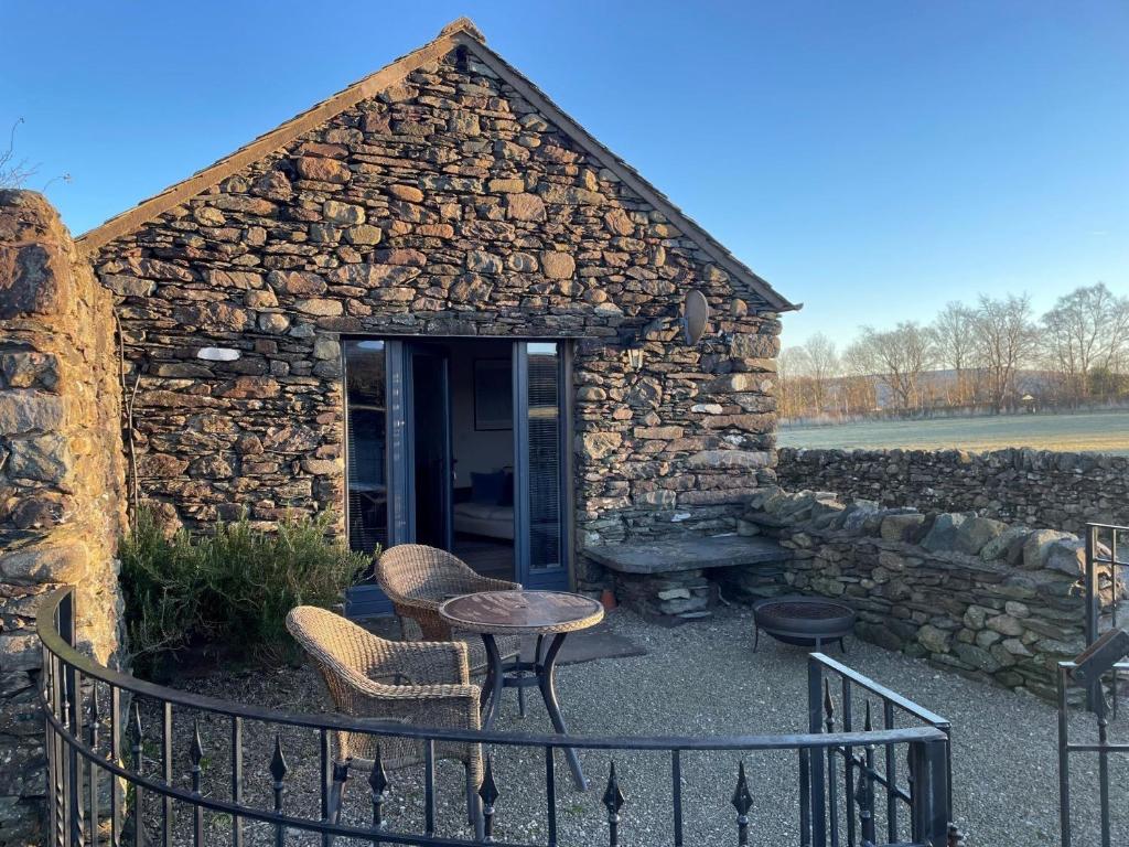 a stone building with a table and chairs in front of it at 1 Bed in Ullswater 94064 in Watermillock