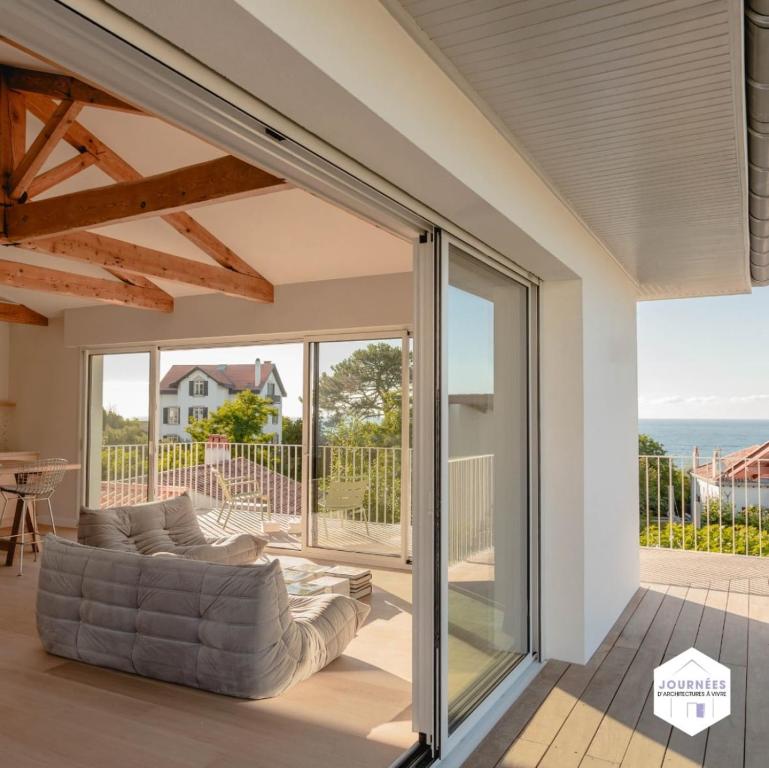 a living room with sliding glass doors and a couch at Villa Txori Habia - House with ocean view in Guéthary