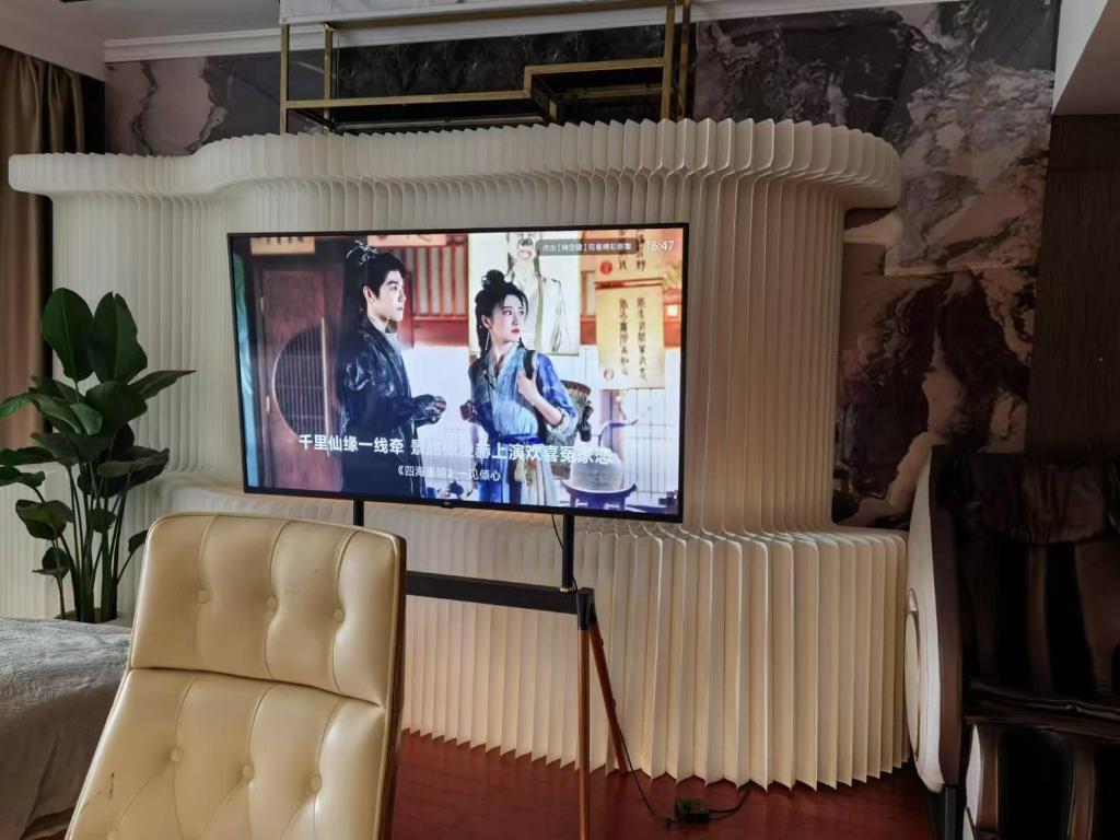 Un televisor sobre un soporte en una sala de estar con un sofá en Panoramic views of the Bund and the Yangtze River, adjacent to the Oriental Pearl Tower, a top-tier luxury residence in Shanghai, en Shanghái