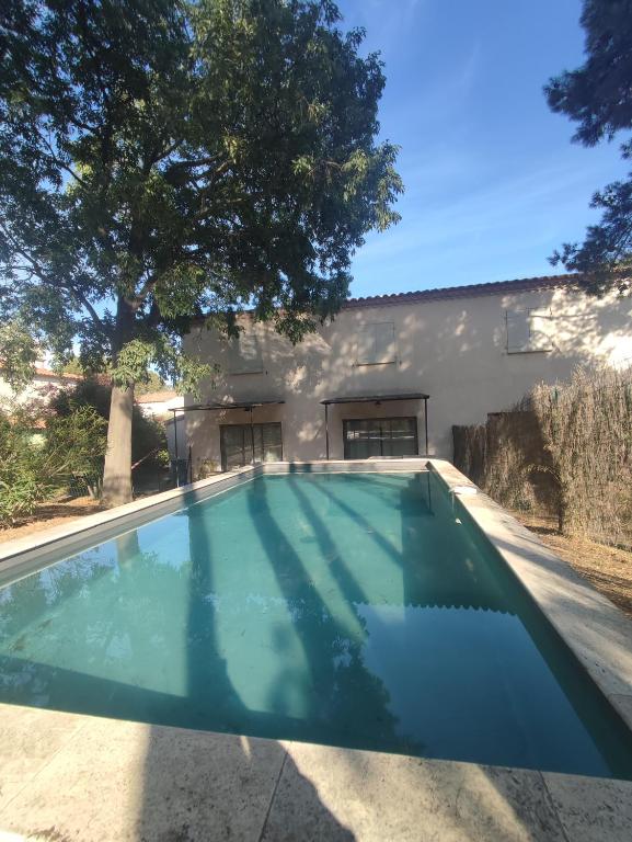an empty swimming pool in front of a house at Villa Élegancia - Piscine privé - Wifi - 18 in Laredorte