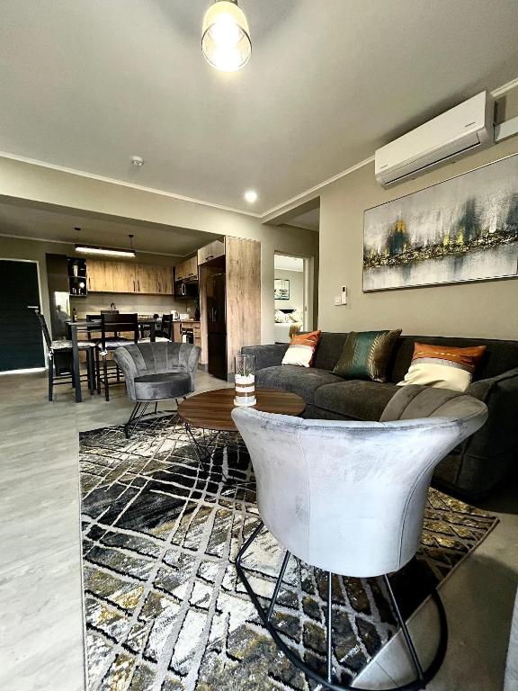 un salon avec un canapé et une table dans l'établissement Cozy Loft, à Gaborone