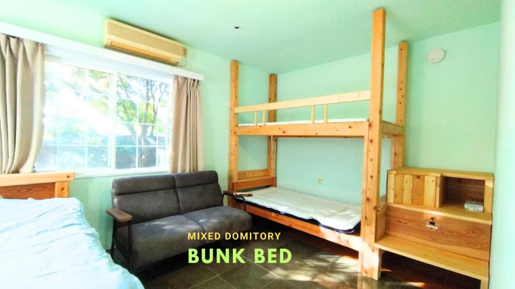 a bedroom with two bunk beds and a chair at Nemurupa Garden Hostel & Yoga in Narita