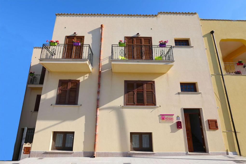 a tall white building with balconies and windows at B&B Orchidea in San Vito lo Capo
