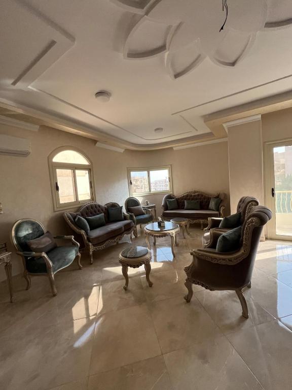 a living room with couches and chairs and a table at Garden View apartment in Madīnat aţ Ţalāʼi‘