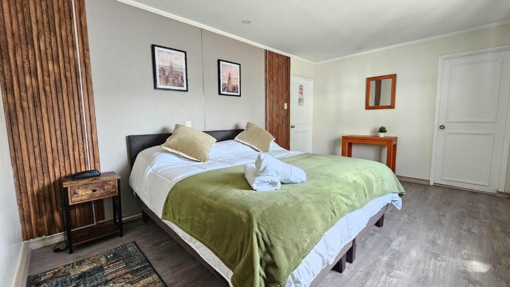 a bedroom with a bed with a cat sitting on it at Hotel Ágora in Viña del Mar