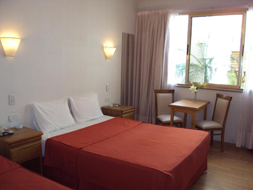 a hotel room with a bed and a table and a window at Hotel Rey in Buenos Aires