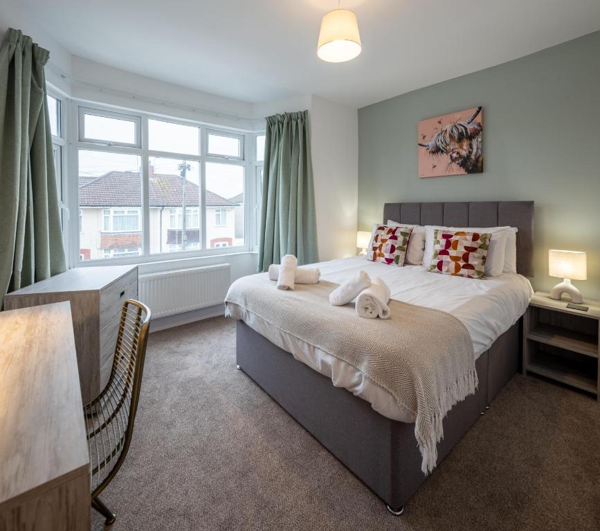 a bedroom with a large bed with towels on it at Kinsale House by Cliftonvalley Apartments in Brislington