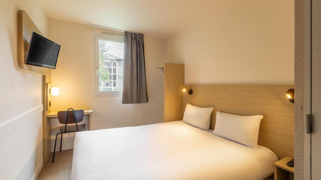 Un pat sau paturi într-o cameră la Premiere Classe Roissy CDG - Paris Nord 2 - Parc des Expositions