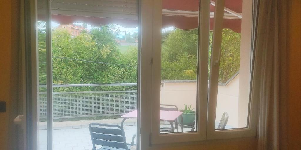a window with a view of a table and chairs at Habitación triple con bañera y terraza HOTEL SUITE MIOÑO in Castro-Urdiales
